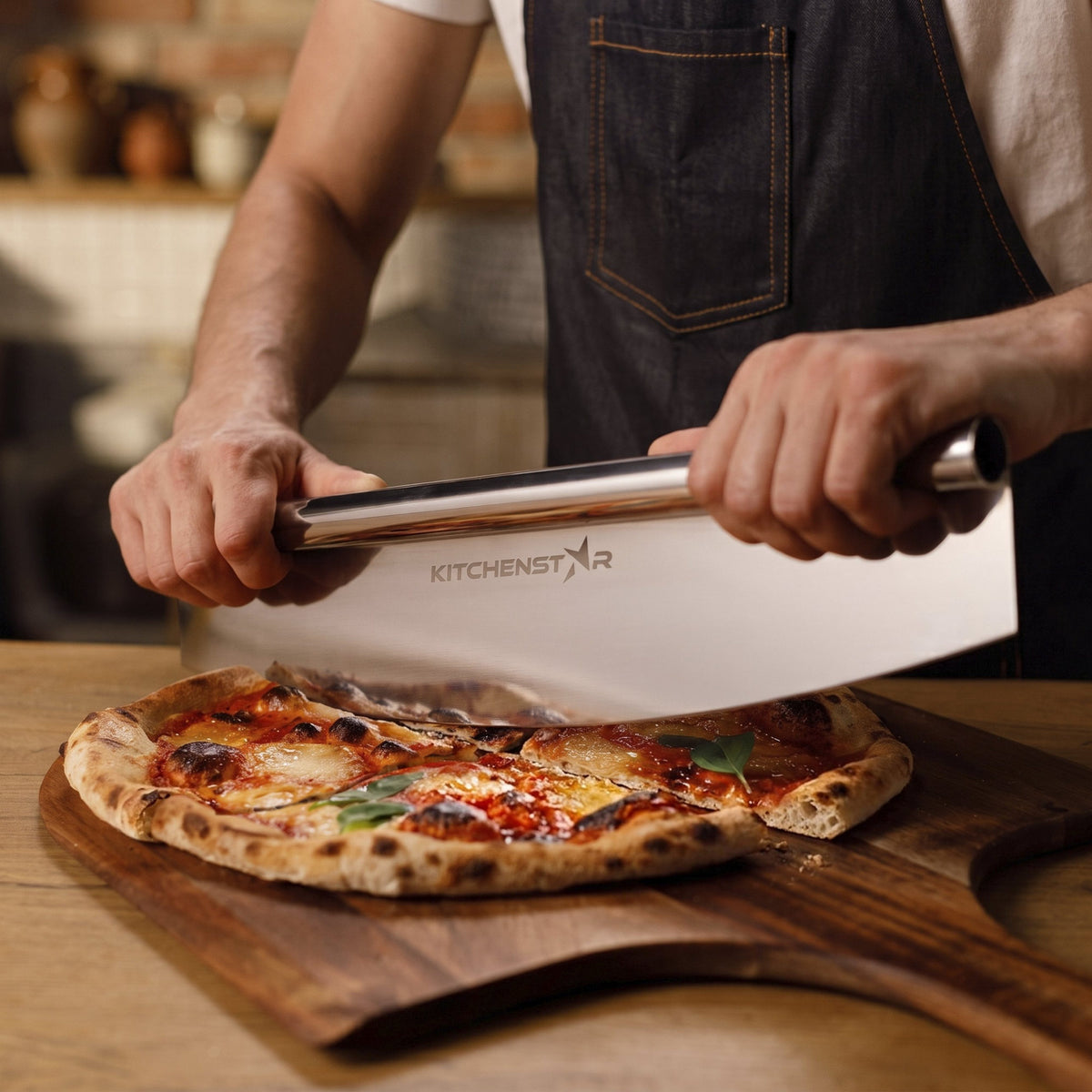 Man slicing pizza on a wooden peel with the KitchenStar 16 inch stainless steel pizza cutter rocker